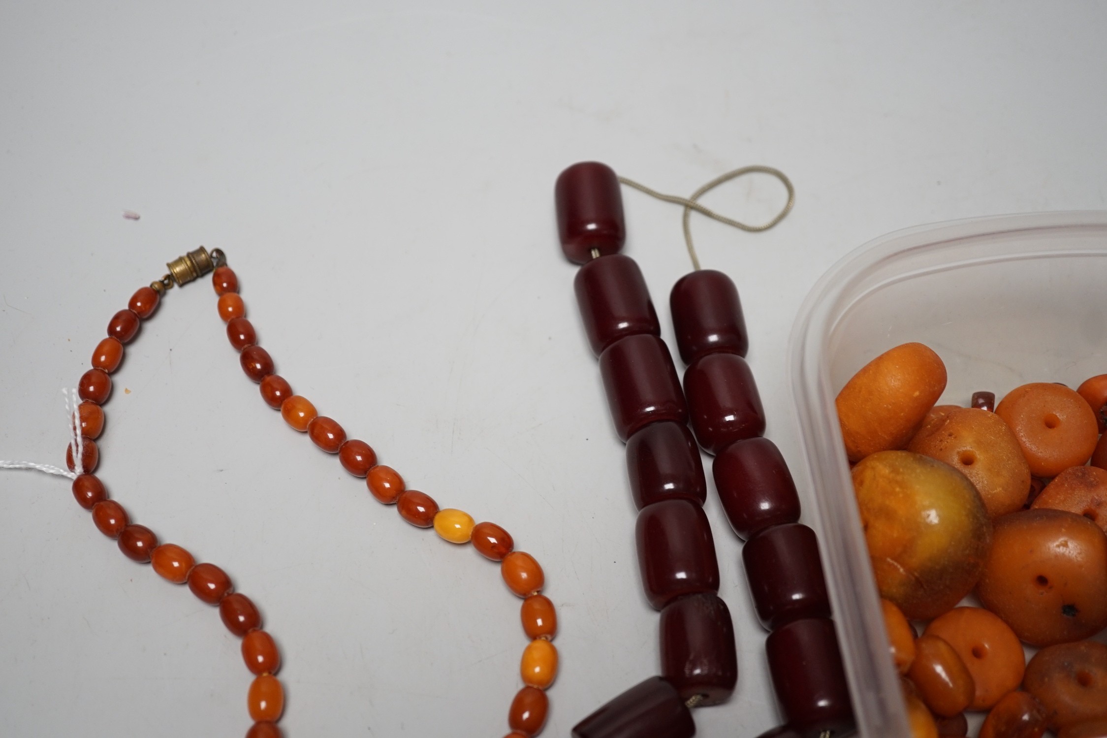 A single strand graduated amber bead necklace, 54cm gross weight 30 grams, together with loose amber beads, gross 153 grams and a simulated cherry amber necklace.